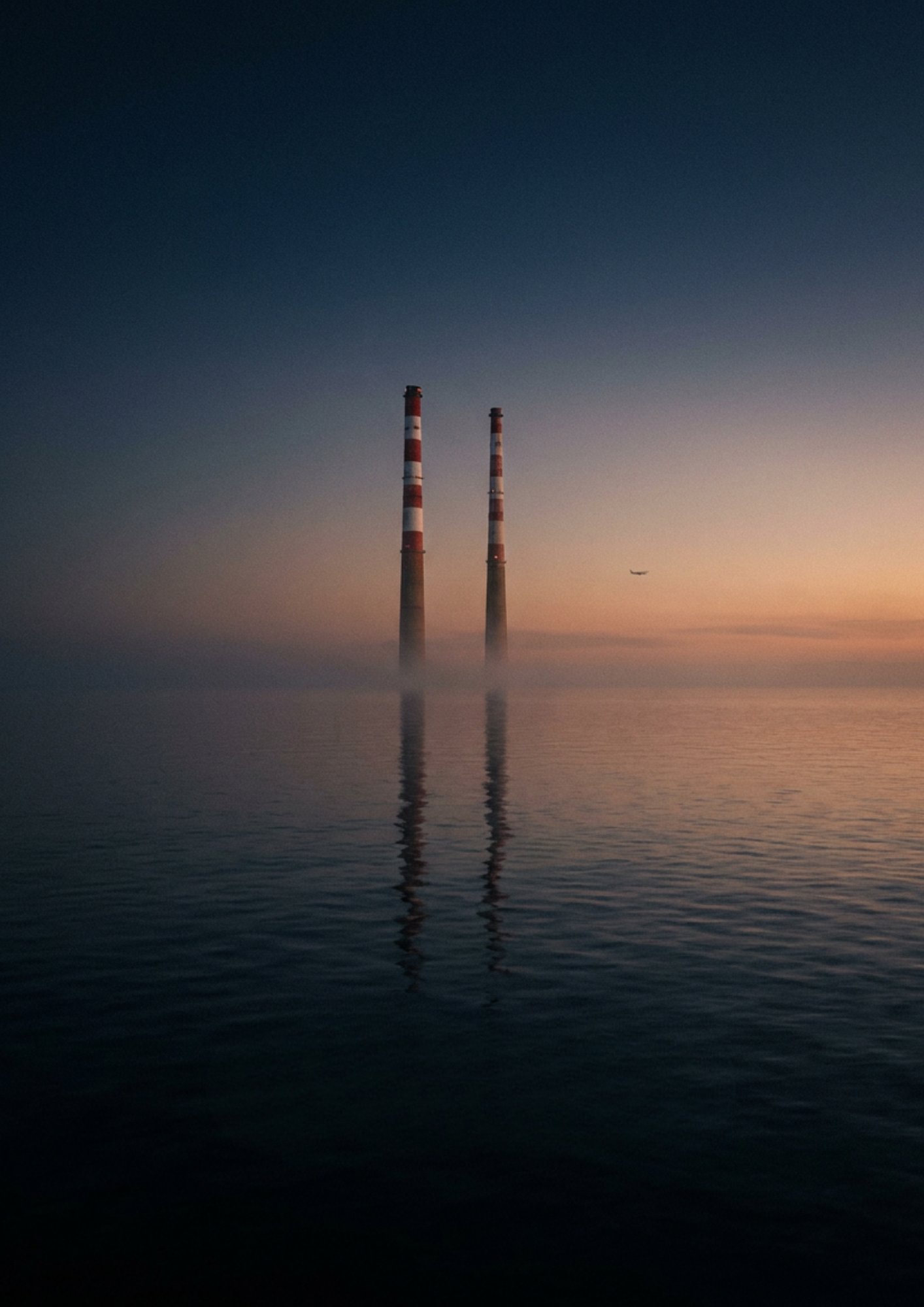 The Poolbeg chimneys rising from a still Dublin Bay at dusk